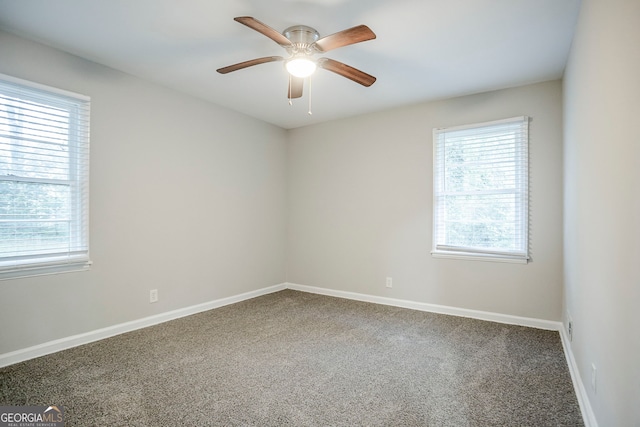 carpeted empty room with ceiling fan, baseboards, and a healthy amount of sunlight