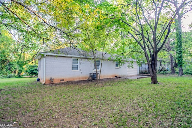 back of property featuring cooling unit, a patio area, crawl space, a yard, and brick siding