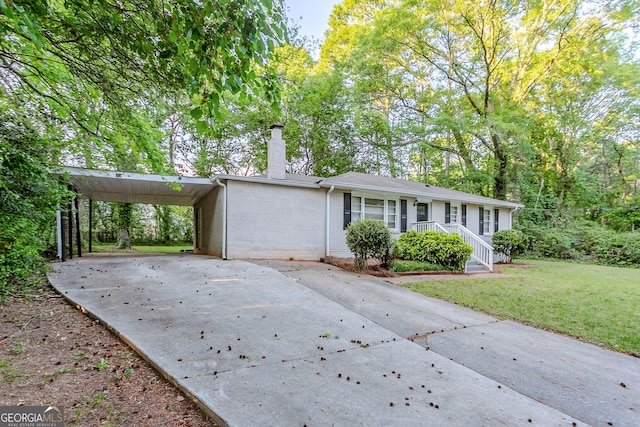 single story home with a chimney, covered porch, a carport, a front yard, and concrete driveway