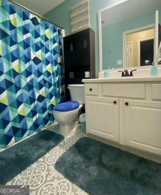 bathroom with a shower with shower curtain, toilet, and vanity