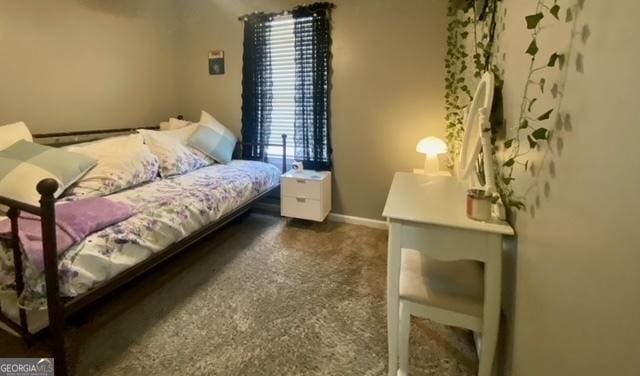 bedroom featuring dark carpet and baseboards