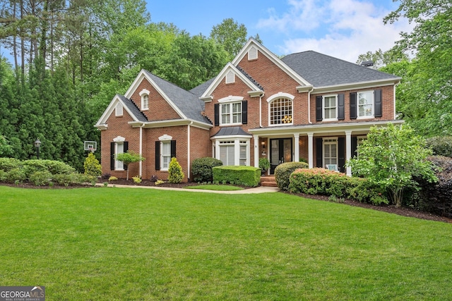 945 Hampton Bluff Dr, Milton, GA 30004 - view of front of home with brick siding, roof with shingles, a front yard, and a porch