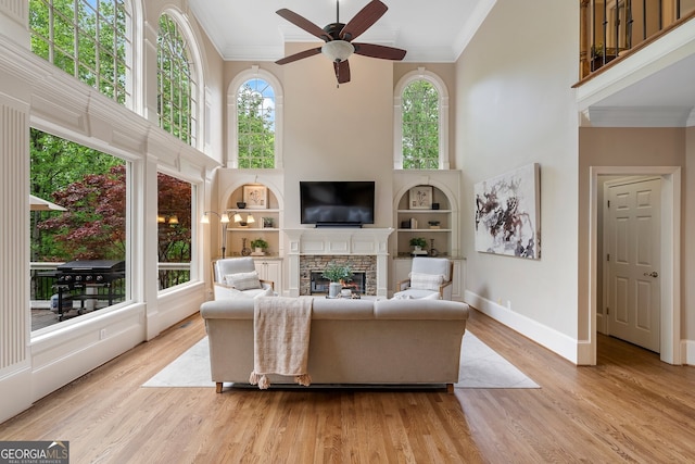 945 Hampton Bluff Dr, Milton, GA 30004 - living area featuring a high ceiling, ornamental molding, ceiling fan, and a fireplace
