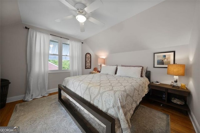 bedroom featuring a ceiling fan, vaulted ceiling, wood finished floors, and baseboards