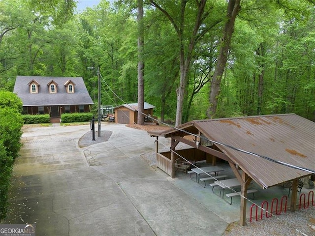 view of patio with an outbuilding and a view of trees