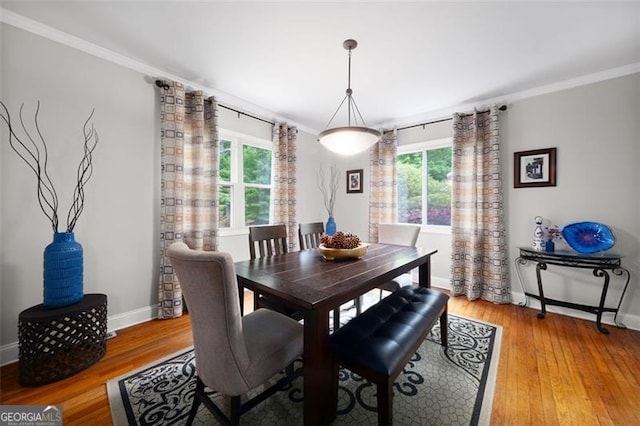 dining area with light wood-type flooring, plenty of natural light, crown molding, and baseboards