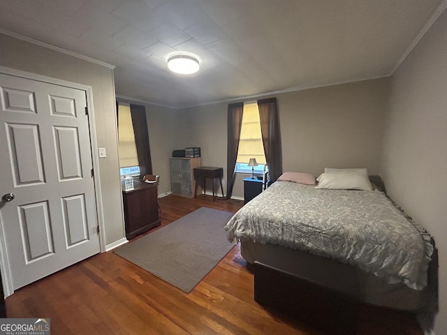 bedroom with ornamental molding and wood finished floors