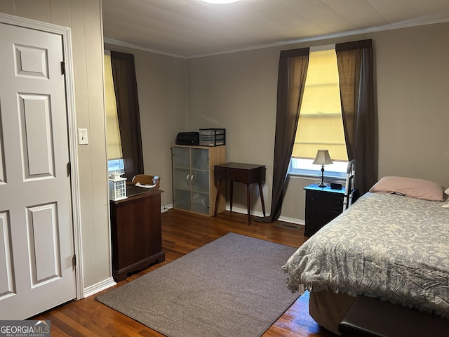 bedroom featuring ornamental molding, visible vents, wood finished floors, and baseboards