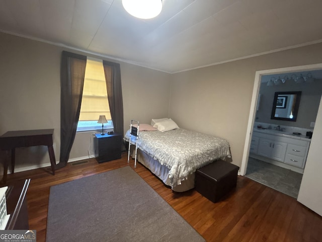 bedroom featuring ornamental molding, a sink, dark wood-style flooring, and connected bathroom