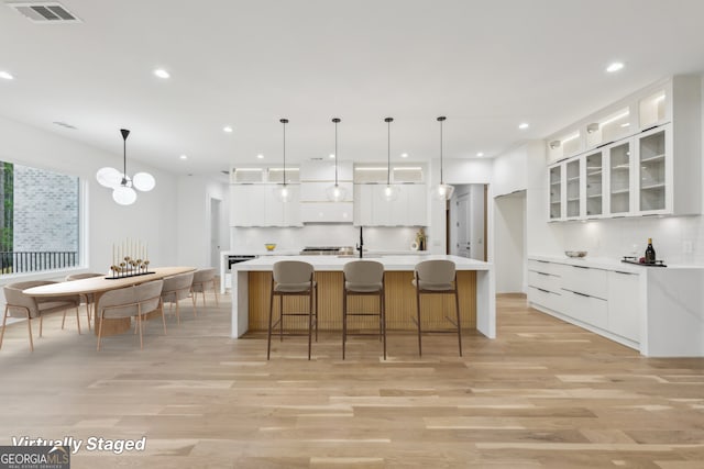 1255 E M Croy Rd, Sugar Hill, GA 30518 - kitchen with light wood-type flooring, backsplash, white cabinetry, recessed lighting, and light countertops
