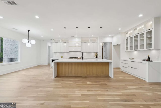 1255 E M Croy Rd, Sugar Hill, GA 30518 - kitchen featuring light wood-style floors, white cabinetry, recessed lighting, light countertops, and glass insert cabinets