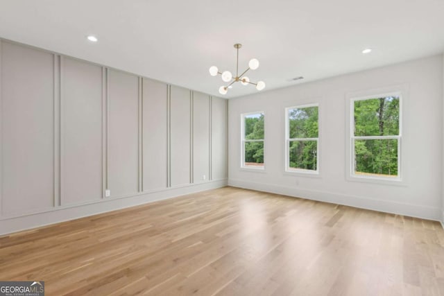 1255 E M Croy Rd, Sugar Hill, GA 30518 - spare room featuring healthy amount of natural light, a chandelier, a decorative wall, light wood-style floors, and recessed lighting