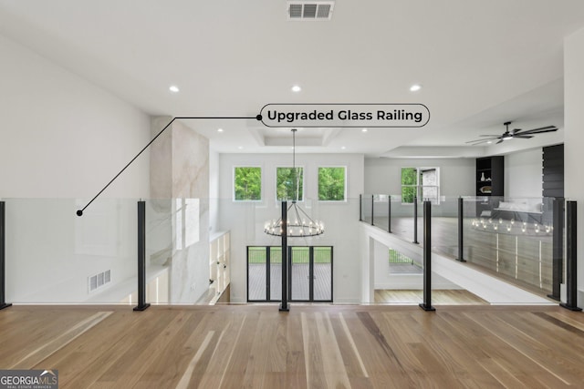 1255 E M Croy Rd, Sugar Hill, GA 30518 - unfurnished living room featuring a chandelier, a raised ceiling, wood finished floors, recessed lighting, and ceiling fan