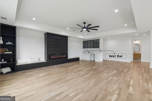 1255 E M Croy Rd, Sugar Hill, GA 30518 - unfurnished living room featuring a raised ceiling, a ceiling fan, light wood-type flooring, a large fireplace, and recessed lighting