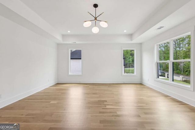 1255 E M Croy Rd, Sugar Hill, GA 30518 - empty room with a chandelier, a raised ceiling, and light wood-style floors