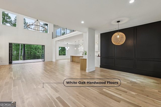 1255 E M Croy Rd, Sugar Hill, GA 30518 - entrance foyer featuring a chandelier, light wood-type flooring, a towering ceiling, recessed lighting, and a decorative wall