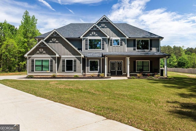 craftsman inspired home featuring a front yard, covered porch, board and batten siding, and fence