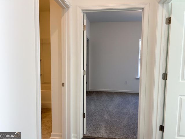 hallway featuring carpet floors and baseboards