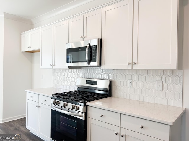 kitchen featuring white cabinets, appliances with stainless steel finishes, light stone counters, tasteful backsplash, and dark wood-type flooring