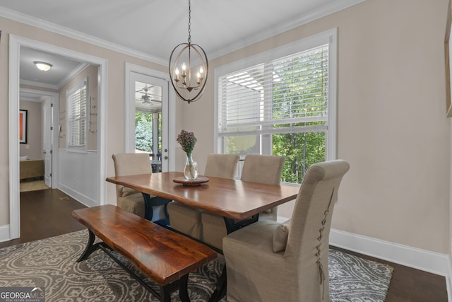 dining space featuring dark wood-style flooring, baseboards, a notable chandelier, and ornamental molding