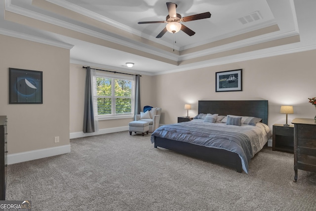 carpeted bedroom with crown molding, visible vents, baseboards, a tray ceiling, and a ceiling fan