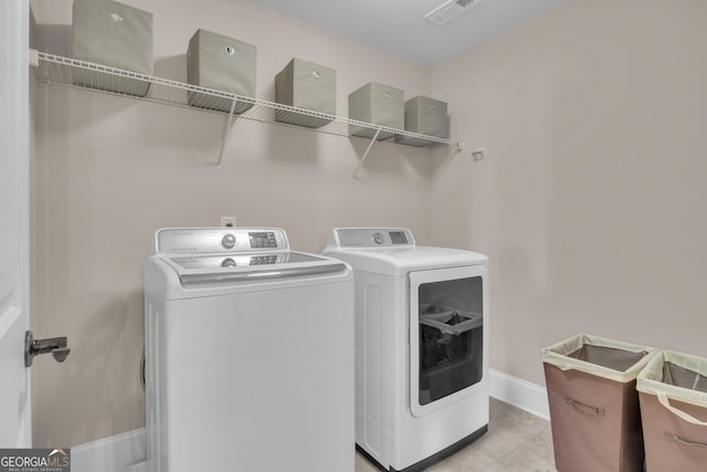 laundry area with baseboards, visible vents, laundry area, and washing machine and clothes dryer