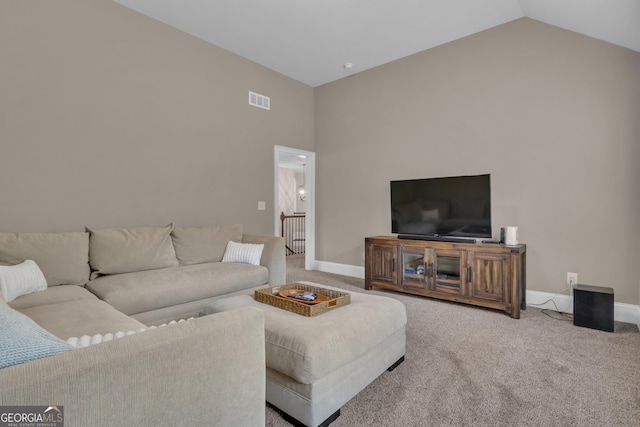 carpeted living area featuring visible vents, baseboards, and high vaulted ceiling