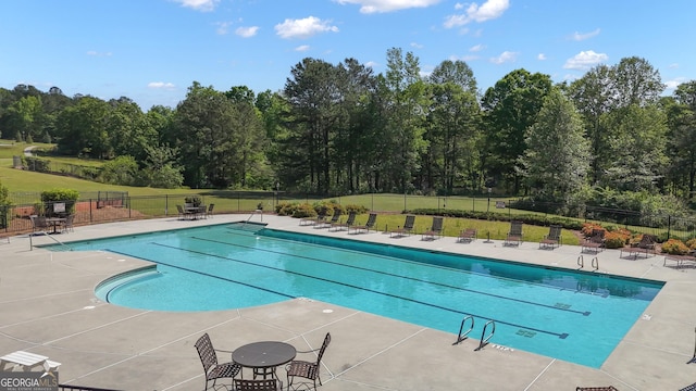 community pool featuring fence, a patio, and a yard