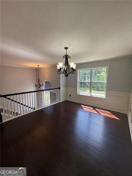 955 Tributary Way, Dacula, GA 30019 - empty room with a chandelier, a wainscoted wall, hardwood / wood-style floors, and crown molding