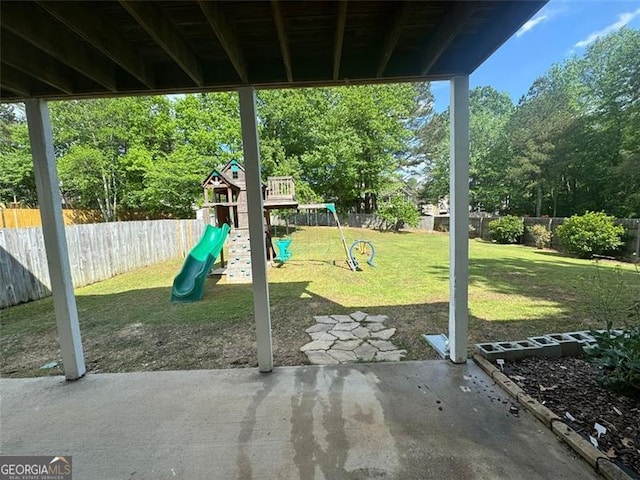 955 Tributary Way, Dacula, GA 30019 - fenced backyard featuring a playground and view of scattered trees