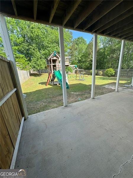 955 Tributary Way, Dacula, GA 30019 - fenced backyard featuring a playground, a patio, and view of scattered trees