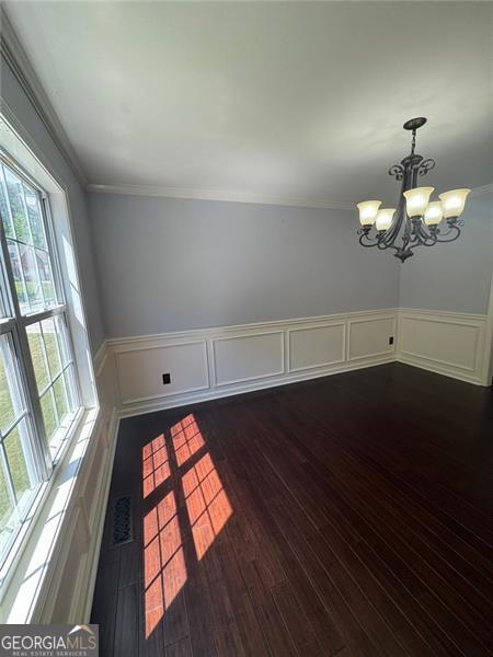 955 Tributary Way, Dacula, GA 30019 - spare room with a chandelier, wainscoting, ornamental molding, dark wood-style floors, and a decorative wall