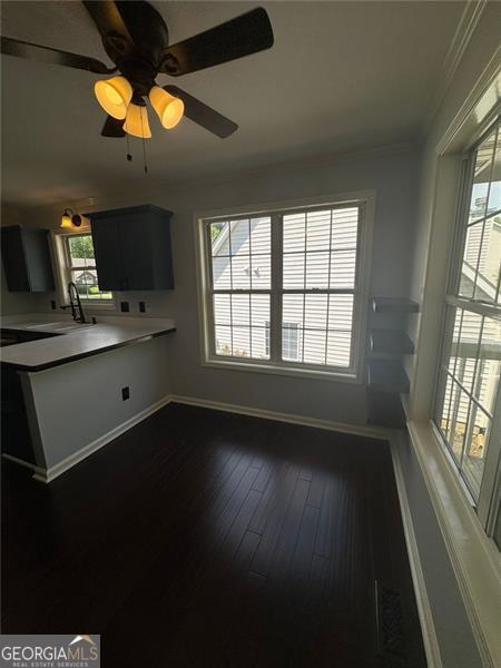 955 Tributary Way, Dacula, GA 30019 - kitchen featuring a sink, crown molding, baseboards, dark wood-style flooring, and light countertops
