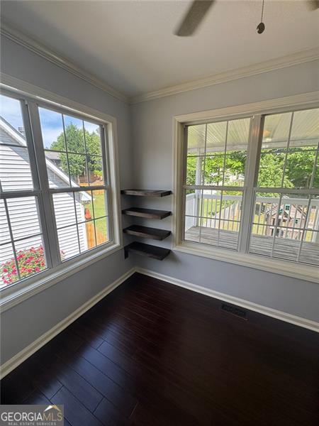 955 Tributary Way, Dacula, GA 30019 - spare room featuring baseboards, crown molding, dark wood-type flooring, and ceiling fan