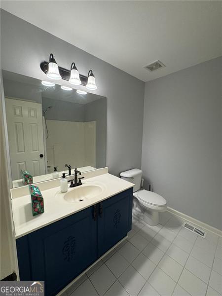955 Tributary Way, Dacula, GA 30019 - bathroom featuring toilet, vanity, a shower, tile patterned flooring, and baseboards