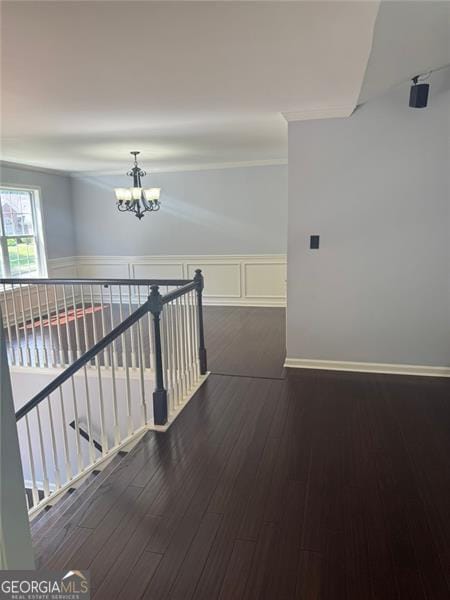 955 Tributary Way, Dacula, GA 30019 - hallway with a chandelier, an upstairs landing, wood finished floors, and a wainscoted wall