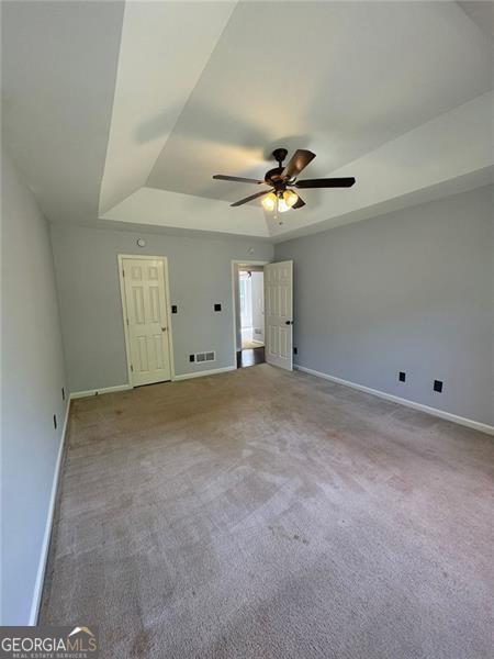 955 Tributary Way, Dacula, GA 30019 - carpeted spare room with a tray ceiling and ceiling fan