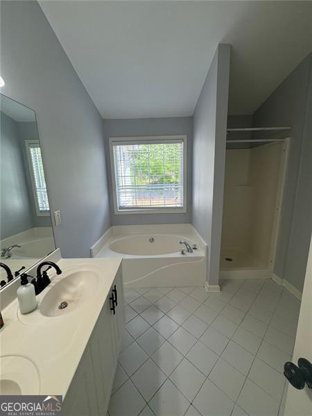 955 Tributary Way, Dacula, GA 30019 - full bath featuring tile patterned floors, a bath, healthy amount of natural light, and a shower stall