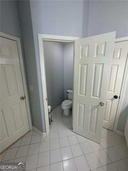 955 Tributary Way, Dacula, GA 30019 - bathroom with tile patterned floors, toilet, and baseboards