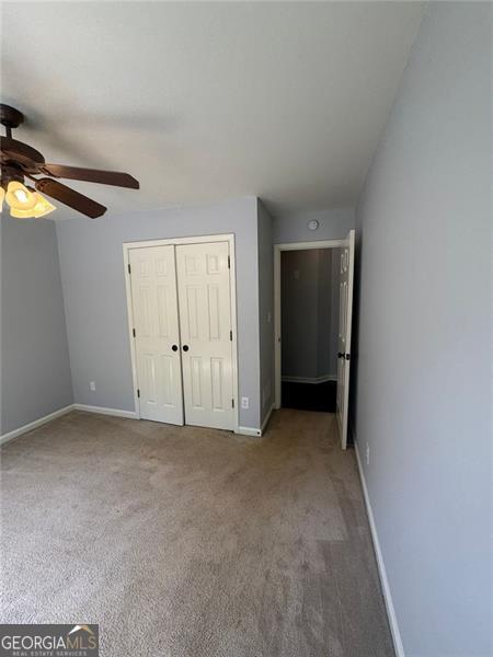 955 Tributary Way, Dacula, GA 30019 - unfurnished bedroom with a closet, carpet, and ceiling fan