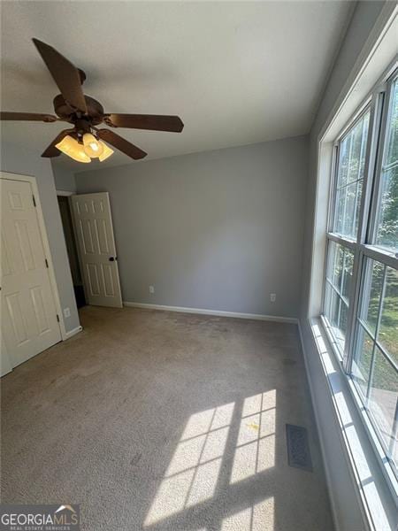 955 Tributary Way, Dacula, GA 30019 - unfurnished bedroom featuring multiple windows, carpet floors, and ceiling fan