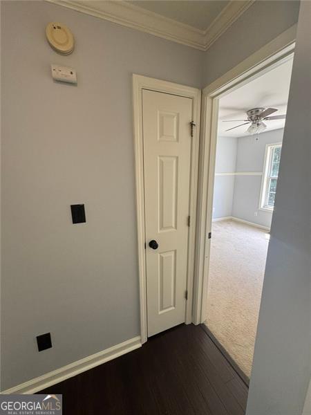 955 Tributary Way, Dacula, GA 30019 - hall with crown molding, dark wood finished floors, dark carpet, and baseboards