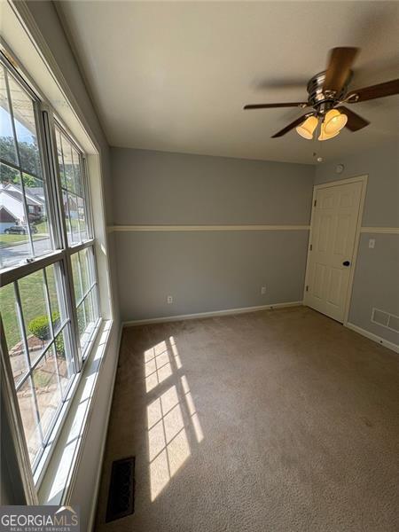 955 Tributary Way, Dacula, GA 30019 - unfurnished room with plenty of natural light, carpet, baseboards, and ceiling fan