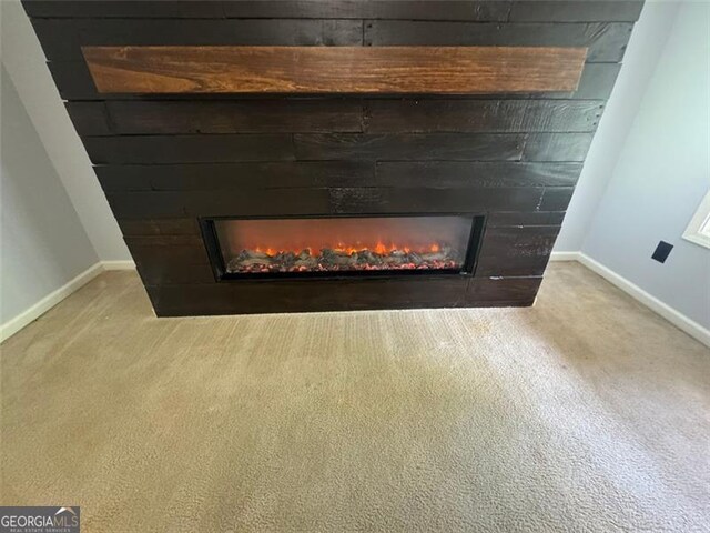 955 Tributary Way, Dacula, GA 30019 - detailed view of a warm lit fireplace, baseboards, and carpet