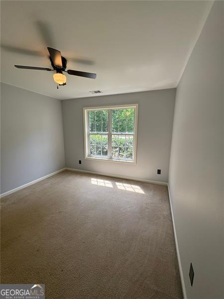 955 Tributary Way, Dacula, GA 30019 - carpeted spare room featuring baseboards and a ceiling fan
