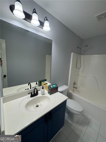 955 Tributary Way, Dacula, GA 30019 - bathroom with tile patterned floors, vanity, toilet, and shower / washtub combination