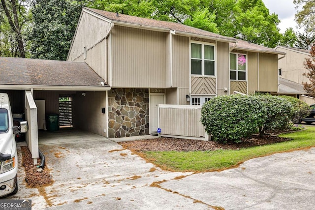 2302 Colonial Dr NE, Brookhaven, GA 30319 - view of front of property with a carport, a shingled roof, concrete driveway, and stone siding
