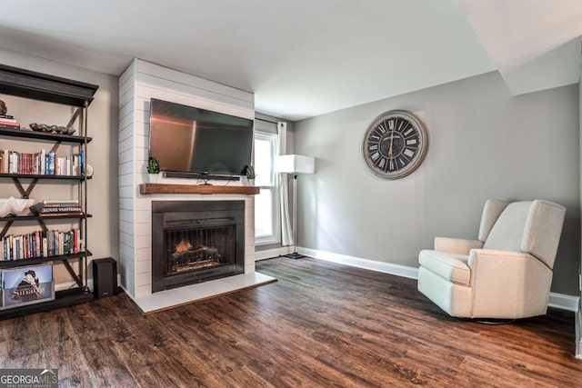 2302 Colonial Dr NE, Brookhaven, GA 30319 - living area featuring wood finished floors, a fireplace with raised hearth, and baseboards