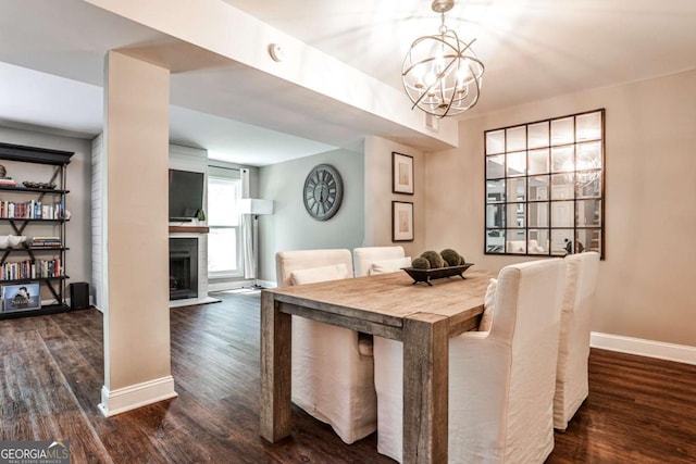 2302 Colonial Dr NE, Brookhaven, GA 30319 - dining area with a fireplace, dark wood-style flooring, a notable chandelier, and baseboards