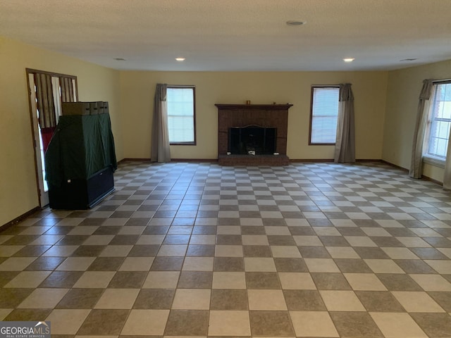 unfurnished living room with baseboards and plenty of natural light